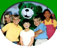 Elementary age children pose with character education-teaching green bear - Kelly Bear